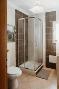 a bathroom with a glass shower with a toilet at Aldeia Caiçara Surf Lodge - Arrifana in Aljezur +31 photos