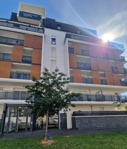 a building with a tree in front of it at Paris Ouest Bezons Appartement entier in Bezons