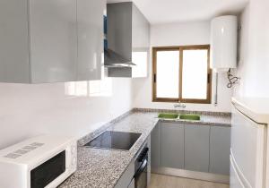 a kitchen with white appliances and a window at Turyva Tarongers 1 - Modern 1-Bedroom Apartment Near the Beach, Costa del Azahar in Peniscola