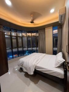 a bedroom with a large bed and a window at Ramona homestay in Kolhapur