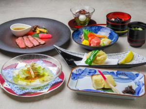 a table with plates of food and bowls of food at Manza Prince Hotel in Tsumagoi +54 photos