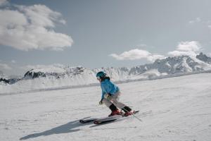 a woman is skiing down a snow covered slope at Brunelle Seiser Alm Lodge in Alpe di Siusi