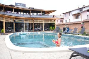 a woman sitting in the pool at a hotel at комплекс Иван и Петър in Belitsa
