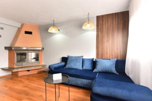 a living room with a blue couch and a fireplace at комплекс Иван и Петър in Belitsa +19 photos