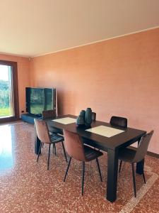 a dining room with a black table and chairs at Residenza Monticelli in Lavagno