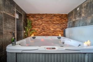 a bath tub in a bathroom with a bottle of champagne at EnergyZen - Spa Alsace - le Refuge des Anges in Bischoffsheim