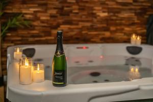 a bottle of wine sitting on a table with candles at EnergyZen - Spa Alsace - le Refuge des Anges in Bischoffsheim