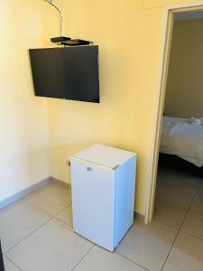 a small white refrigerator in a room with a tv at Otam-Check Guest House in Ondangwa