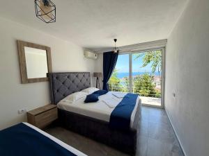 a bedroom with a bed and a large window at Molla Apartments in Ulcinj