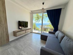 a living room with a couch and a television at Molla Apartments in Ulcinj