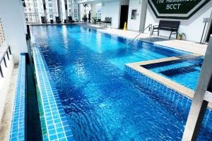 a large swimming pool with blue water in a building at Brittany Hotel BGC in Manila
