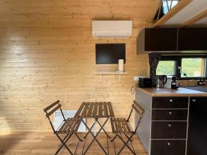 a kitchen with two chairs and a table in a room at Ezy House by Tiny Away in Ézy-sur-Eure