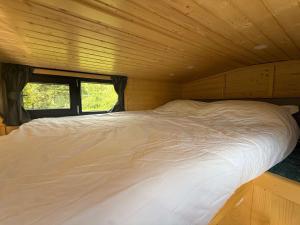 a large white bed in a wooden room at Ezy House by Tiny Away in Ézy-sur-Eure