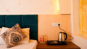 a bed with a coffee maker on a night stand at River Town Stays in Varanasi +24 photos