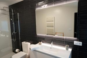 a bathroom with a sink and a toilet and a mirror at La Marisol Ribeira in Ribeira