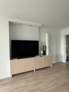 a living room with a large flat screen tv on a wall at The North Antwerp Apartment in Antwerp