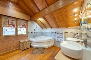 a bathroom with a large tub and two sinks at Chalet Du Pont Des Fées in Gérardmer +28 photos