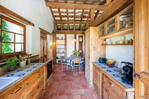 a kitchen with wooden cabinets and a table with chairs at Dependance avec Jacuzzi in Arcangues +19 photos