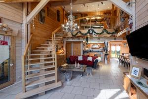 a living room with a staircase in a log cabin at Chalet Du Pont Des Fées in Gérardmer