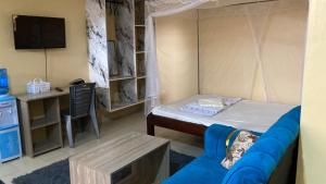 a room with a bed and a desk with a tv at Margin Diani in Ukunda