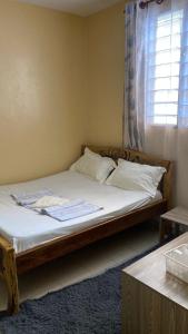 a bed sitting in a room with a window at Margin Diani in Ukunda