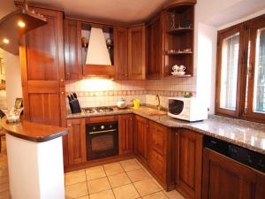 Una cocina con gabinetes de madera y microondas. en Le Maree Susanna, en Rio Marina