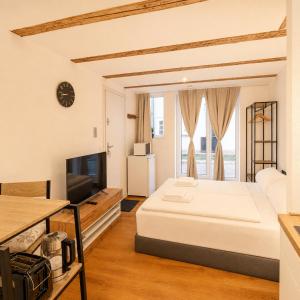 a bedroom with a large bed and a television at Wismar Apartments - Cozy and Central in Wismar