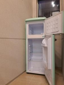 a small white refrigerator with its door open at お部屋に露天風呂 自分専用の湯船に新鮮な熱海温泉を入れる贅沢 新築美麗AtamiOnsenApart104 in Atami