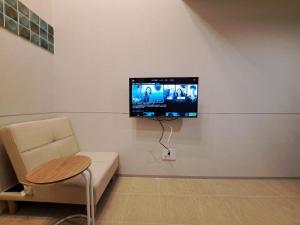a room with a couch and a tv on a wall at お部屋に露天風呂 自分専用の湯船に新鮮な熱海温泉を入れる贅沢 新築美麗AtamiOnsenApart104 in Atami