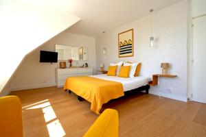 a bedroom with a king sized bed with yellow sheets at La Villa des Sables in Concarneau