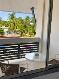 ein Balkon mit Tisch und Stühlen und Palmen in der Unterkunft Keya hotel samui in Plai Laem