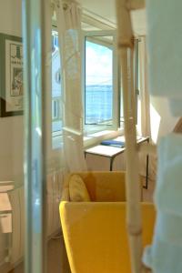 a living room with a yellow couch and a window at La Villa des Sables in Concarneau