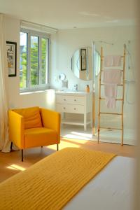 a bathroom with a yellow chair and a sink at La Villa des Sables in Concarneau +89 photos