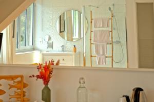 a bathroom with a mirror and a sink at La Villa des Sables in Concarneau