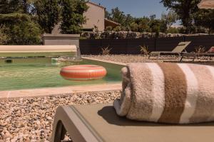 a blanket sitting on a bench next to a pool with a frisbee at Villa des Roches - Labeaume in Labeaume