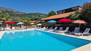 a swimming pool with chairs and umbrellas at Gojim Casa Rural in Armamar