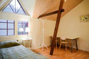 a bedroom with a bed and a desk and a window at Kivimäen Matkailutila in Masku