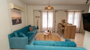 a living room with blue couches and a table at Fereniki Lemnos Suites in Platy
