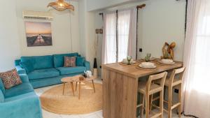a living room with a blue couch and a table at Fereniki Lemnos Suites in Platy