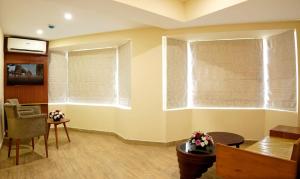 a living room with a window with blinds at Hotel Sea Blue MALLAPPALLY in Vennikulam