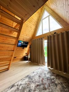 a attic room with a large window and a curtain at A-Frame House Tosor in Tossor