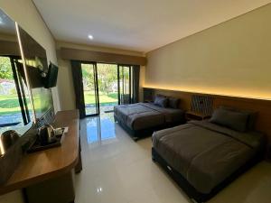 a hotel room with two beds and a television at Puri Bali Hotel in Lovina +54 photos