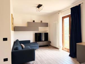 a living room with a blue couch and a tv at Casa vacanze Adri in Faggeto Lario 