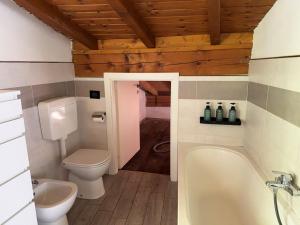a bathroom with a tub and a toilet and a sink at Casa vacanze Adri in Faggeto Lario  +32 photos