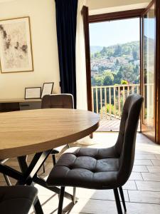 a table and chairs in a room with a balcony at Casa vacanze Adri in Faggeto Lario 