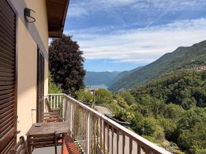 a balcony with a wooden bench and a view of a valley at Casa vacanze Adri in Faggeto Lario 