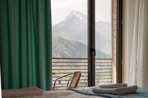 a room with a bed and a view of a mountain at Kazbegi Hotel Grand View in Kazbegi +20 photos