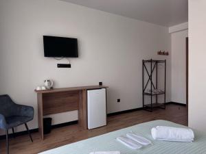 a room with a bed and a desk and a television at Kazbegi Hotel Grand View in Kazbegi