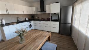 a kitchen with white cabinets and a table with flowers at Living in Rheine in Rheine