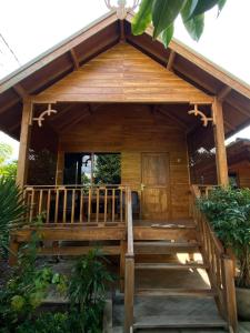 a wooden cabin with stairs leading to the front door at Han's Villa in Sumbawa Besar